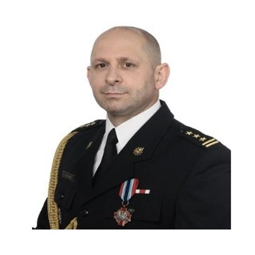 Na zdjęciu w mundurze wyjściowym na jasnym tle Zastępca Komendanta Miejskiego Państwowej Straży Pożarnej w Przemyślu st. bryg. Grzegorz Latusek