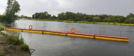Zapora sztywna pomostowa rozłożona na powierzchni rzeki Dunajec. Element ćwiczeń mających na celu ograniczenie rozprzestrzeniania się zanieczyszczeń.
