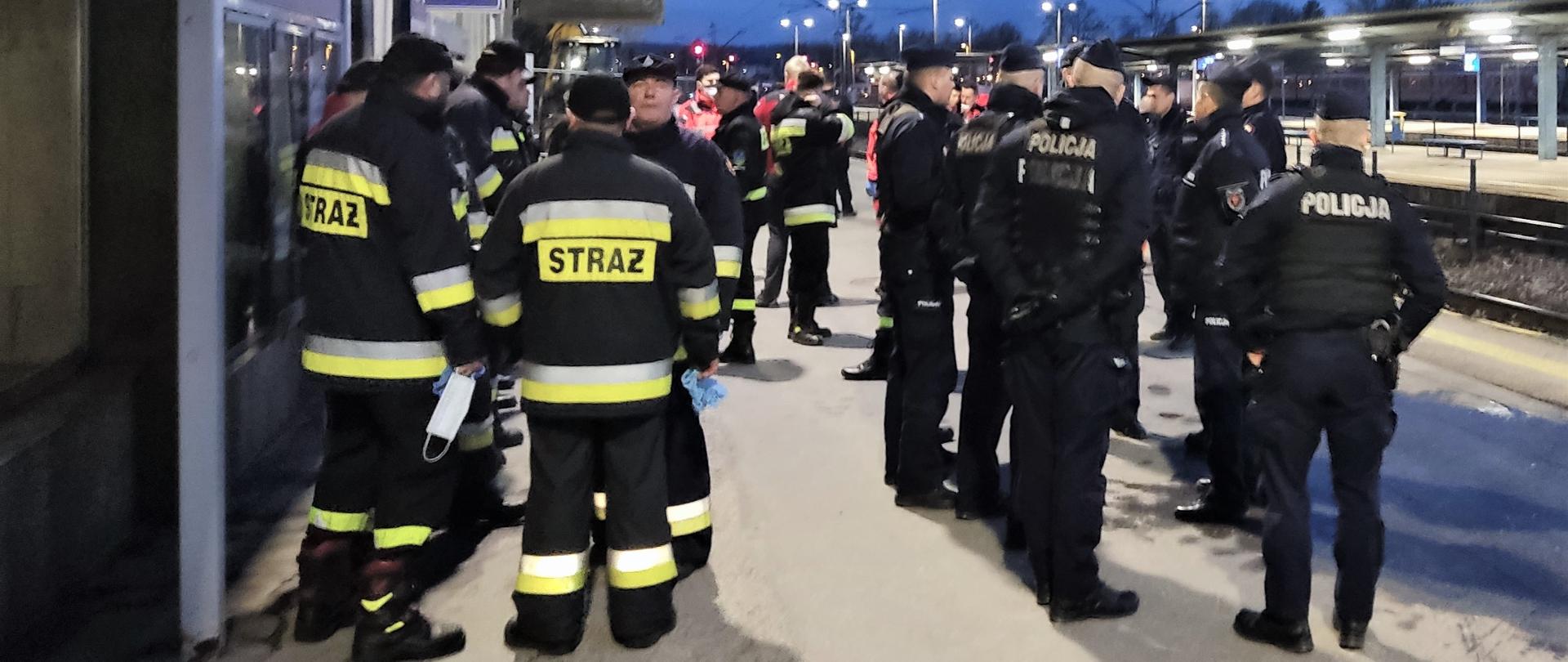 Na zdjęciu przedstawiono dworzec kolejowy w Kielcach. Na pierwszym funkcjonariusze Policji oraz strażacy oczekujący na zapowiedziany pociąg.