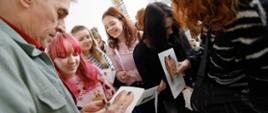 Autor wystawy rozdający autografy uczniom PLSP