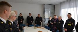 - Funkcjonariusze i pracownicy cywilni oraz zaproszeni goście podczas wigilijnego spotkania – zdjęcie grupowe przy stole z potrawami wigilijnymi