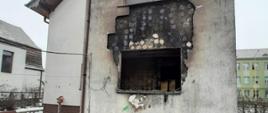 Widok elewacji budynku po pożarze. Widoczny otwór po wypalonym oknie.