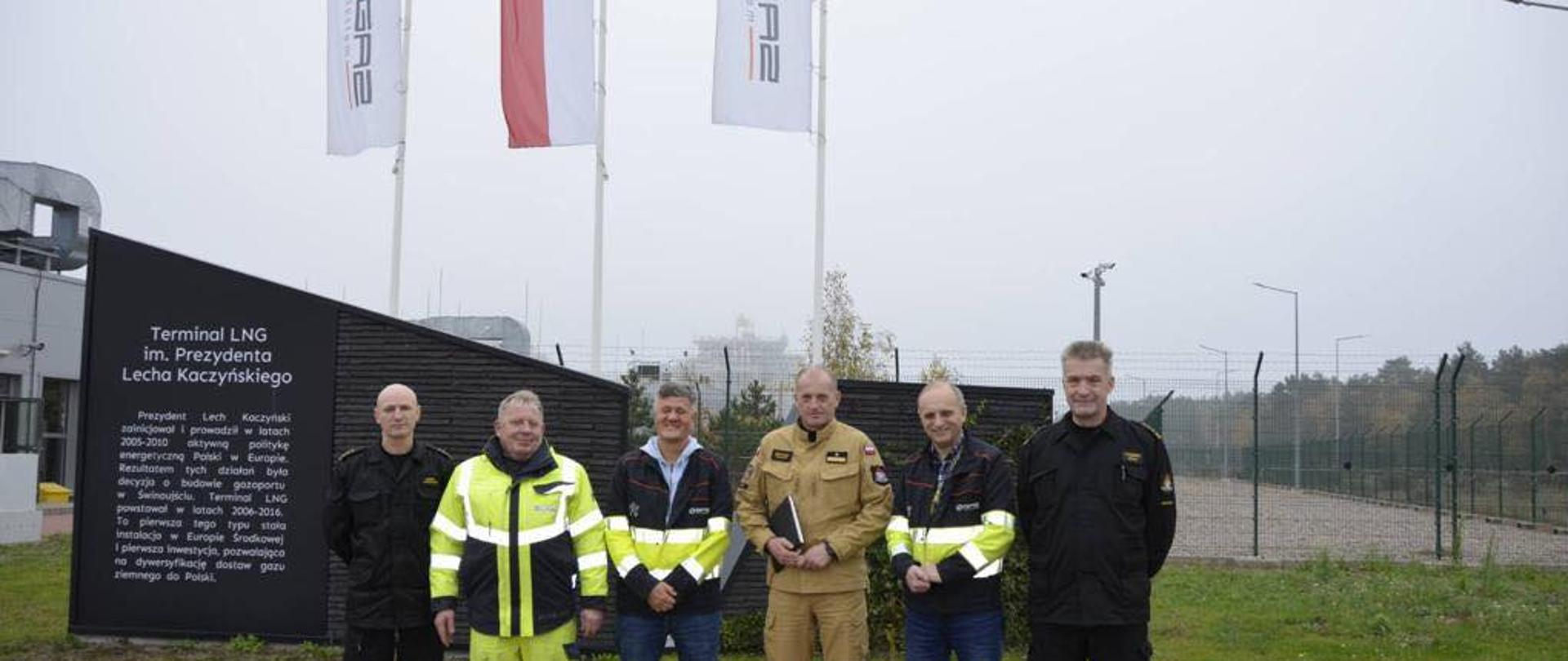 Przy stoliku. Od lewej st. kpt. Marek Wieczorek, przedstawiciele gaz system, nadbryg. Jarosław Tomczyk, kolejny przedstawiciel oraz st .bryg. Kazimierz Lesisz.
W tle Terminal LNG