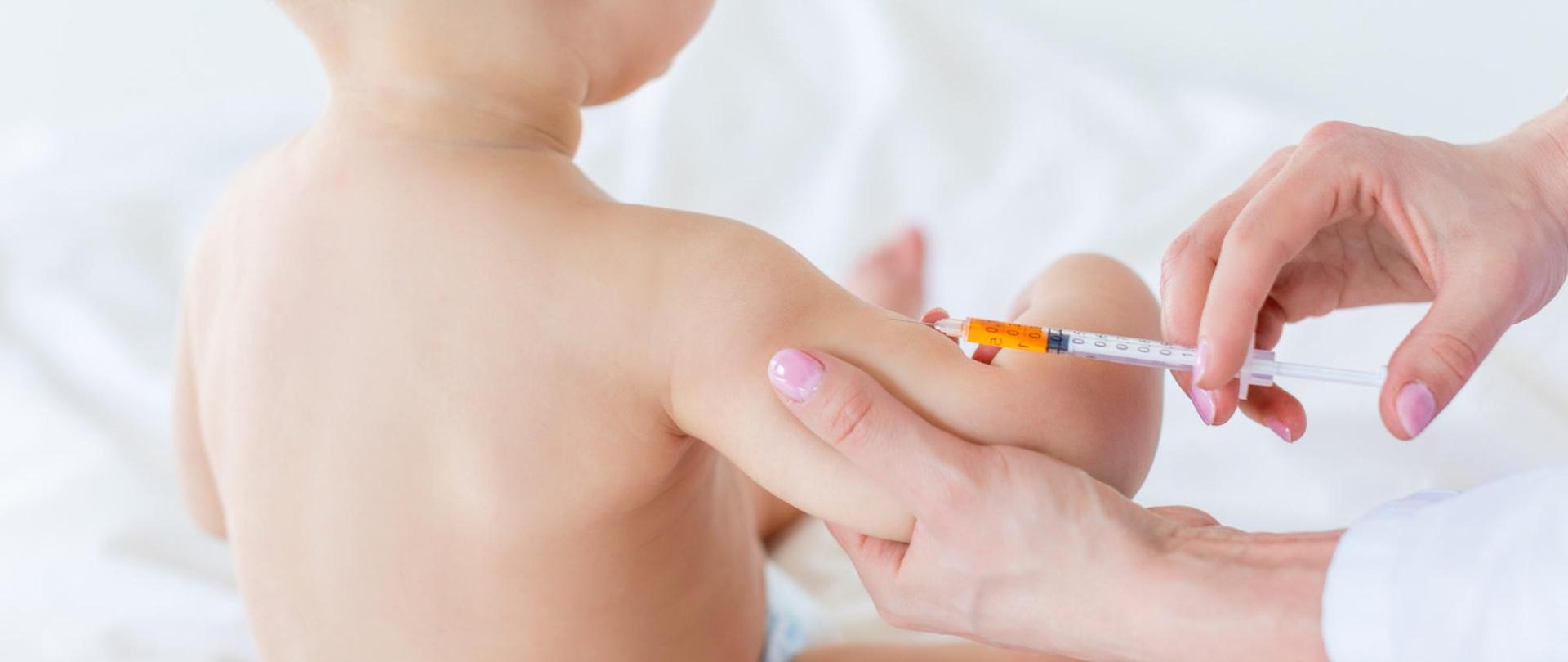 Na zdjęciu jest widoczne dziecko, które jest szczepione przez lekarza.