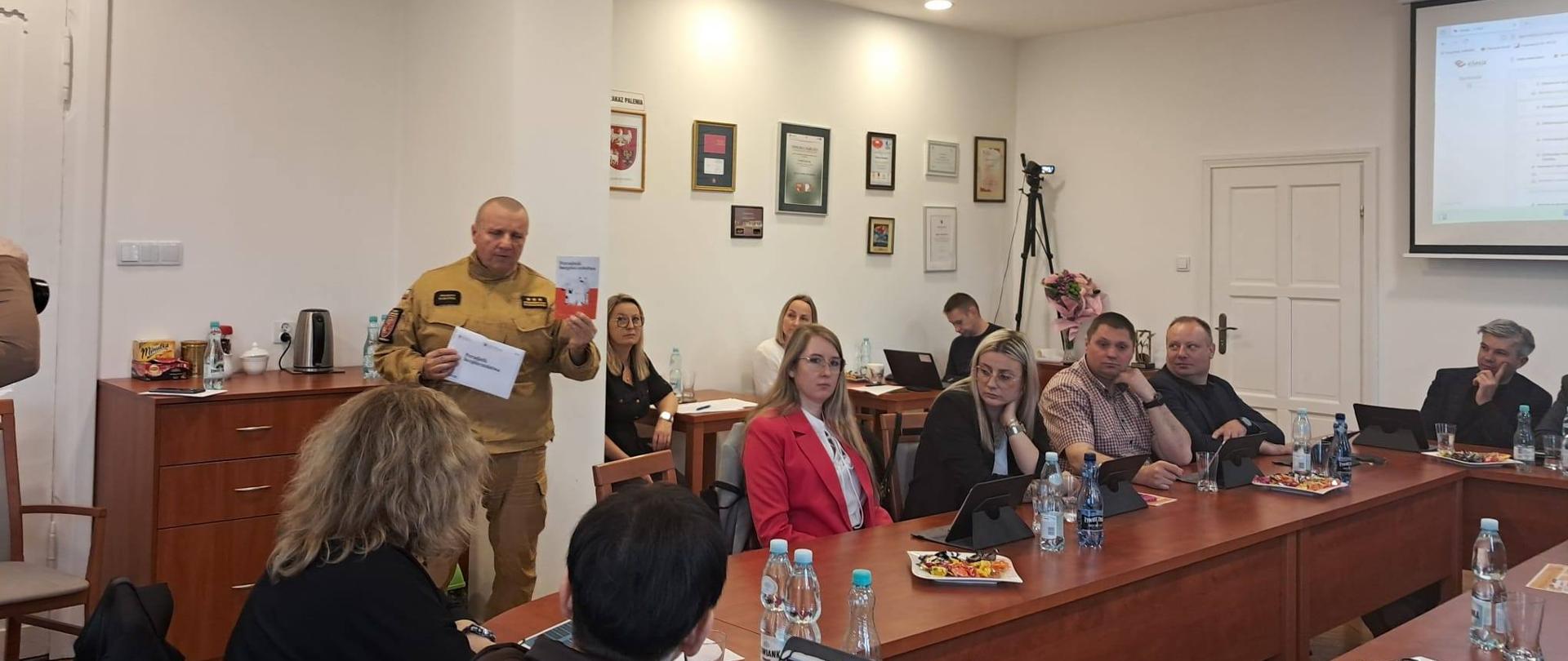 Komendant powiatowy państwowej straży pożarnej przemawia przed radnymi na sesji rady gminy Braniewo.