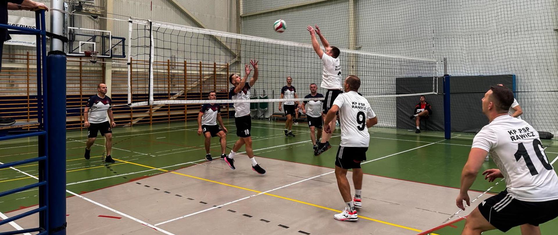 Uczestnicy zawodów w trakcie rozgrywki przy siatce.