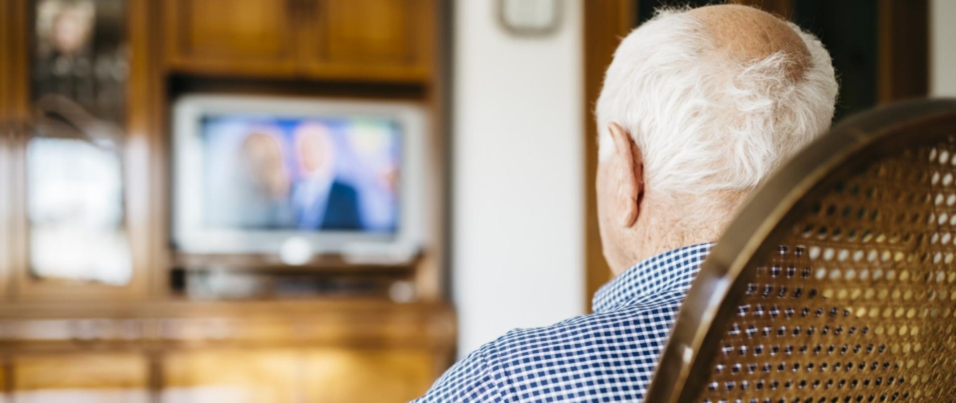 starszy człowiek ogląda telewizję