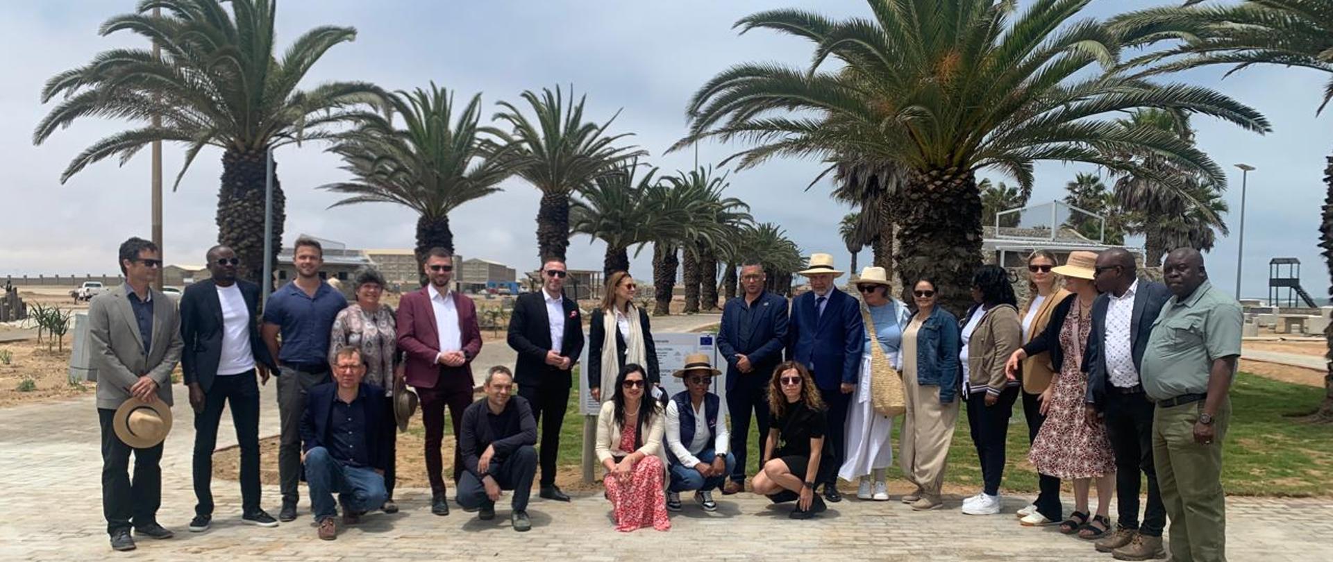 A group of 21 persons, at the back park and playground, lots of palm trees