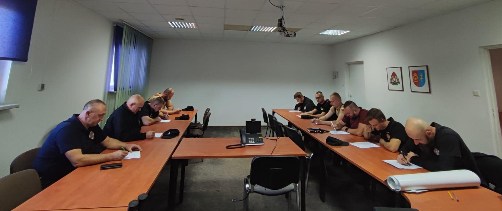 W sali konferencyjnej w KP PSP w Ostrowcu Św. przy stolikach siedzą druhowie OSP, którzy piszą egzamin na dowódców OSP.