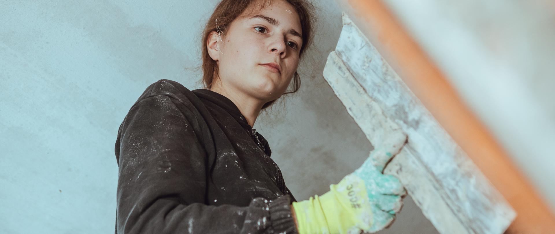 Osoba odnawiająca ścianę