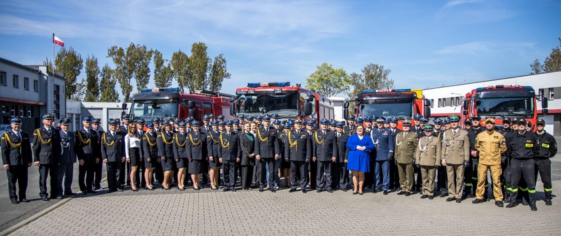 Wspólne grupowe zdjęcie gości, przedstawicieli instytucji współpracujących z Państwową Strażą Pożarną, funkcjonariuszy i pracowników Komendy Wojewódzkiej PSP w Opolu, Komendantów oraz Zastępców Komendantów powiatowych i miejskiego PSP województwa opolskiego oraz strażaków z JRG 2 Opole.