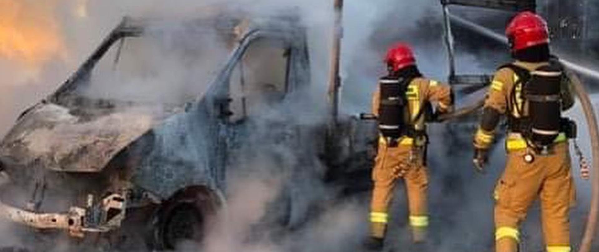 widoczne miejsce zdarzenia, strażacy prowadzący działania ratownicze oraz zniszczony pojazd.