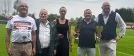 Grupa pięciu osób uczestniczących w wydarzeniu pozuje do zdjęcia. Dwie osoby trzymają puchar. Wśród uczestników znajduje się wicewojewoda w zielonej kurtce, który wręczył drużynie nagrodę w wysokości 3 tysięcy złotych.