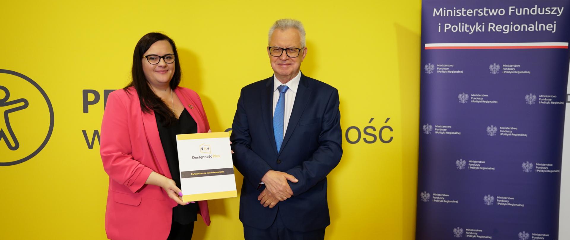 Wiceminister Małgorzata Jarosińska-Jedynak i prezes Krzysztof Michałkiewicz prezentują dokument na tle ścianki