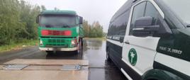 Od lewej: kierowca wywrotki przygotowuje się do wjazdu na inspekcyjne wagi. Urządzenia pomiarowe są rozłożone obok oznakowanego furgonu mazowieckiej Inspekcji Transportu Drogowego.