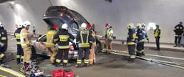 Strażacy oraz policjanci podczas działań w zderzeniu dwóch samochodów osobowych w tunelu 