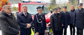Zdjęcie zrobione na zewnątrz, przed remizą strażacką podczas uroczystego przekazania samochodu dla OSP Krempna