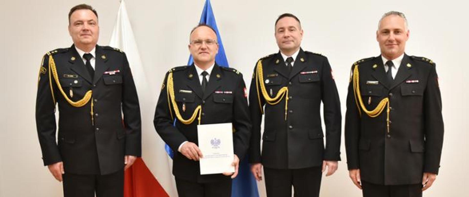 brygadier Lusa, młodszy brygadier Jagodziński starszy brygadier Kościsty oraz brygadier Łukasik pozują do zdjęcia na tle flag ue i polski