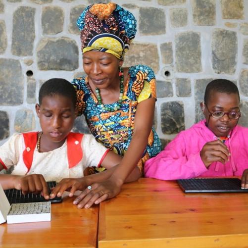 dwóch chłopców wraz z nauczycielką układa klocki służące do nauki matematyki