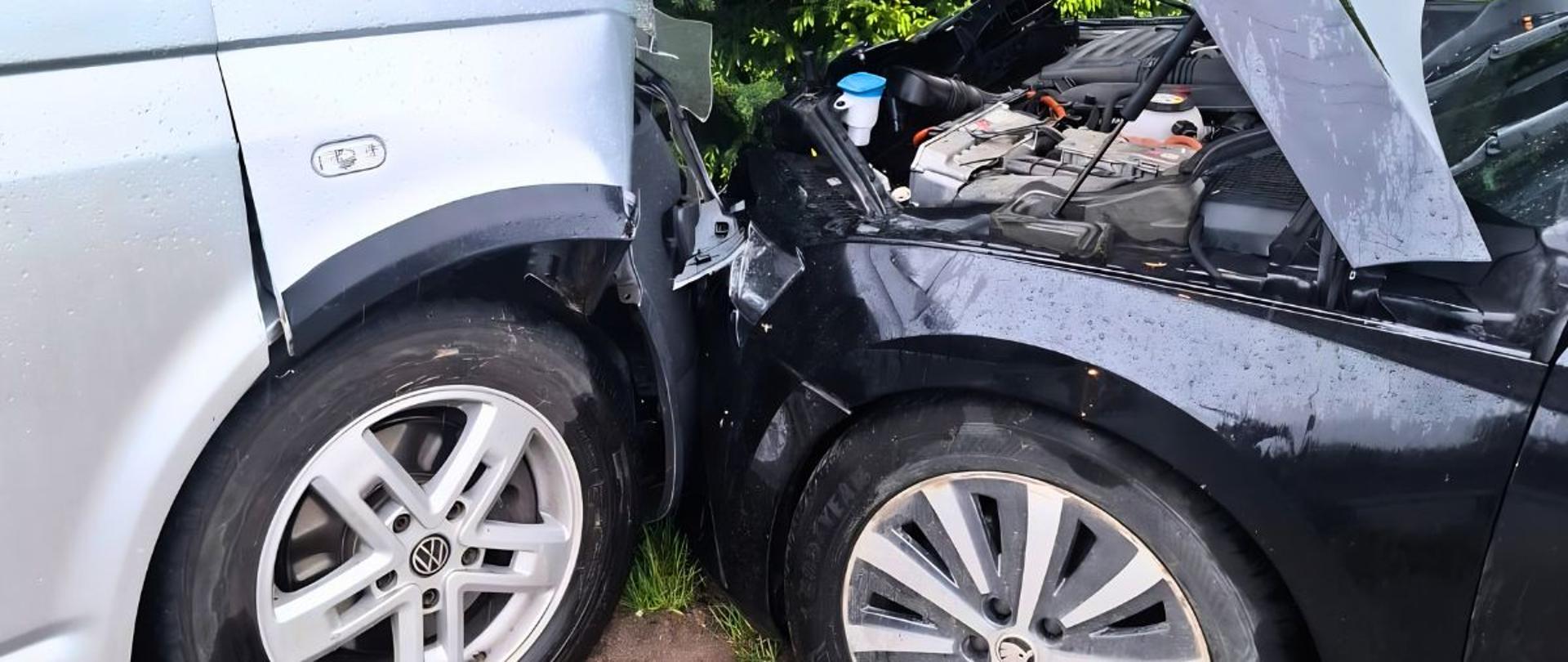 Czołowe zdarzenie dwóch pojazdów, czarnego samochodu osobowego ze srebrnym busem.