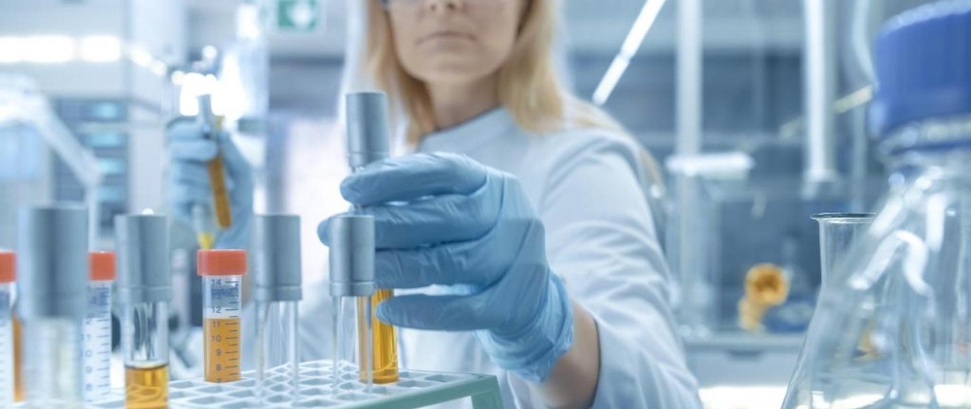 Zdjęcie pracownika laboratorium przy stole laboratoryjnym