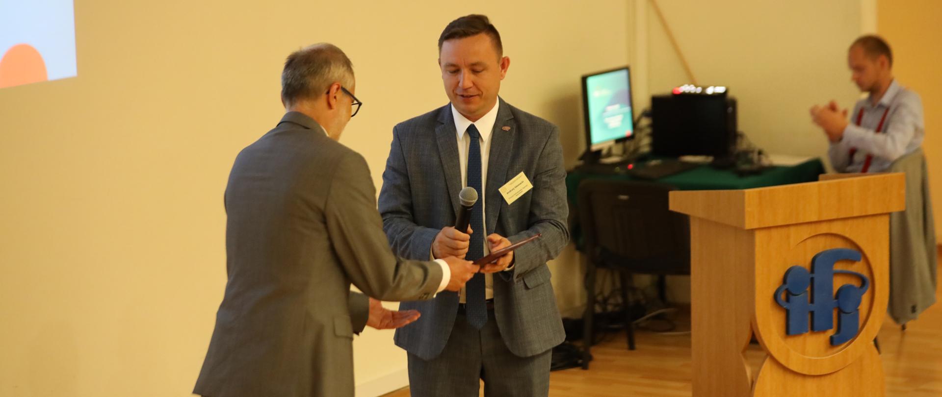 Prezes PAA Andrzej Głowacki (z prawej) wręczył dyrektorowi Instytutu Fizyki Jądrowej Polskiej Akademii Nauk Tadeuszowi Lesiakowi (z lewej) decyzję o autoryzacji 