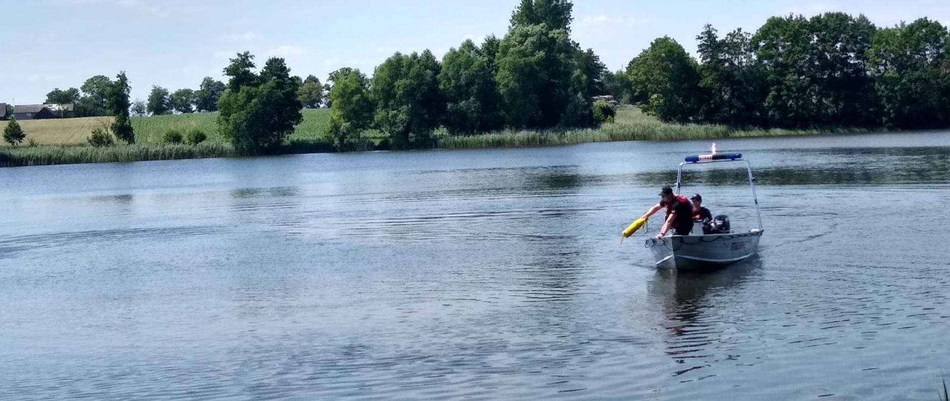 Strażacy PSP w łodzi operujący pasem typu Węgorz