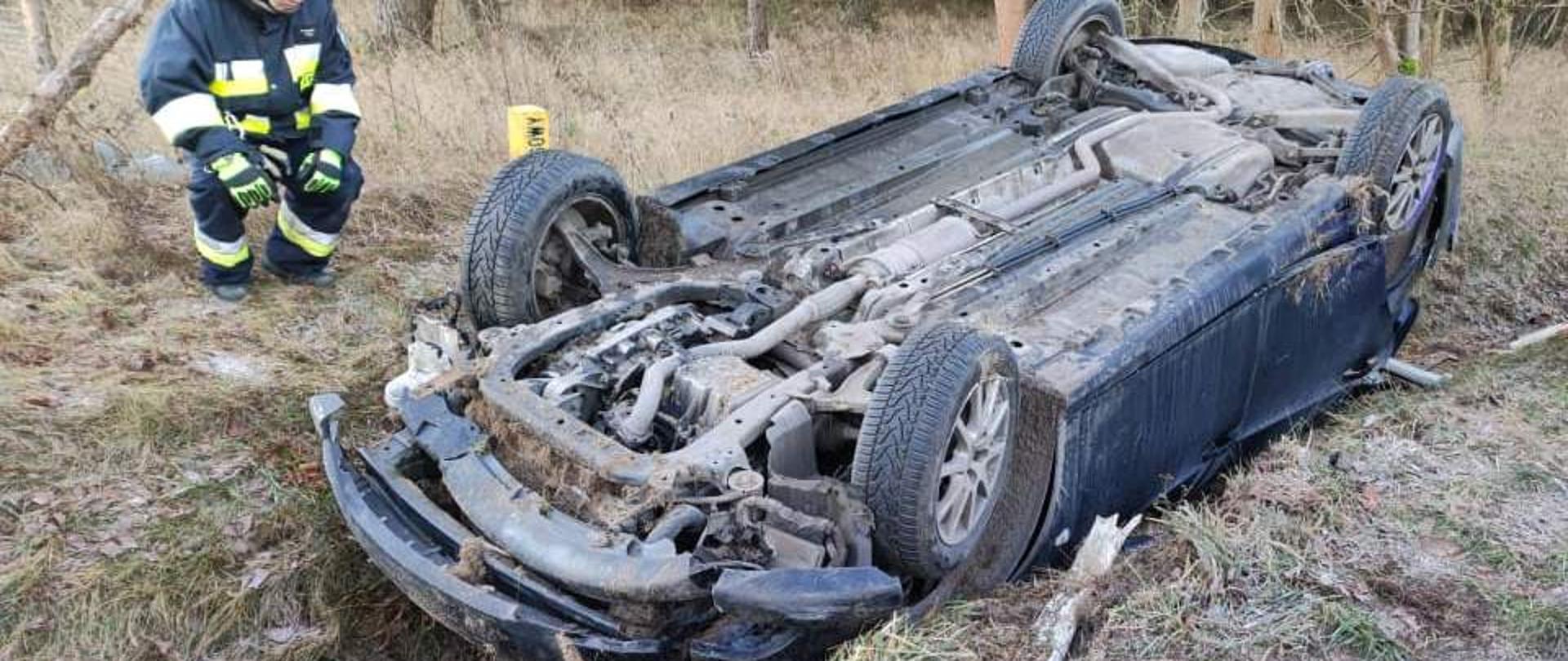 Widać samochód osobowy po dachowaniu w rowie