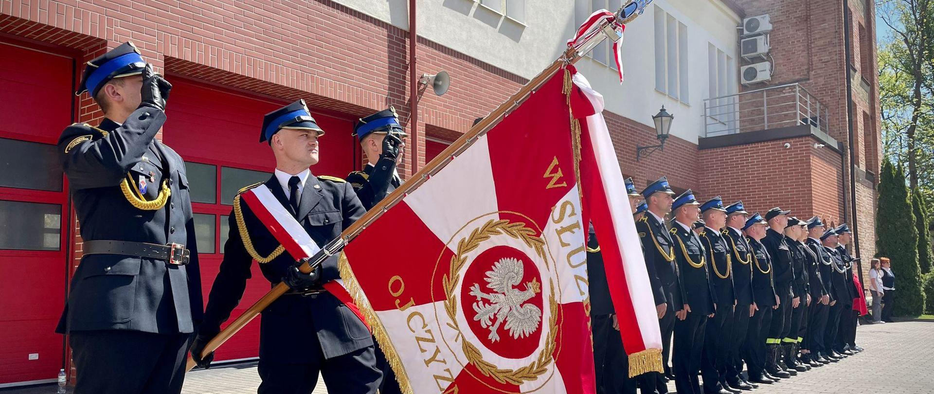 Na zdjęciu widać poczet sztandarowy, strażaków na zbiórce z okazji uroczystych obchodów miejskiego dnia strażaka.
