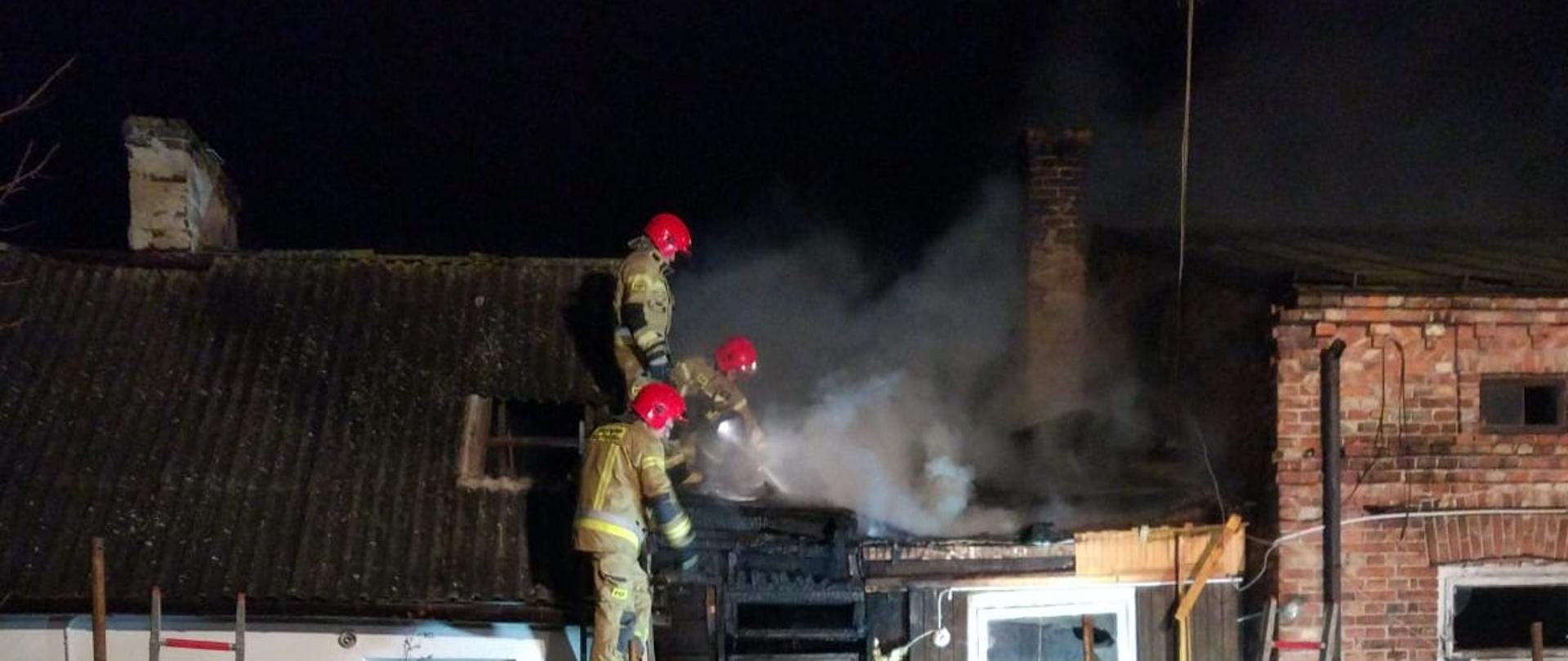 Zdjęcie ukazujące strażaków gaszących budynek