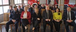 Zdjęcie przedstawia siedzących uczestników uroczystego apelu na krzesłach. w pierwszym rzędzie wielkopolski Komendant Wojewódzki PSP, Poseł Katarzyna Sójka, Europoseł Andżelika Możdżanowska, Minister Jan Dziedziczak oraz samorządowcy powiatu kępińskiego