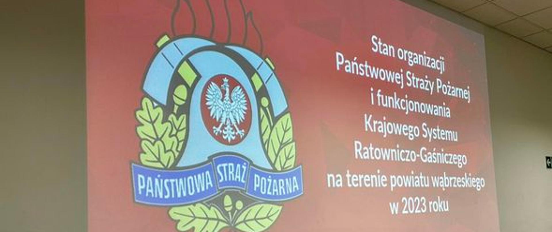 W Komedzie Powiatowej Państwowej Straży Pożarnej trwa narada roczna. Celem narady jest podsumowanie minionego roku w jednostce. Slajd tytułowy prezentacji pt. Stan organizacji PSP i funkcjonowania KSRG na terenie powiatu wąbrzeskiego w 2023 r.