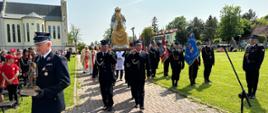 strażacy niosą figurę matki bożej saletyńskiej 