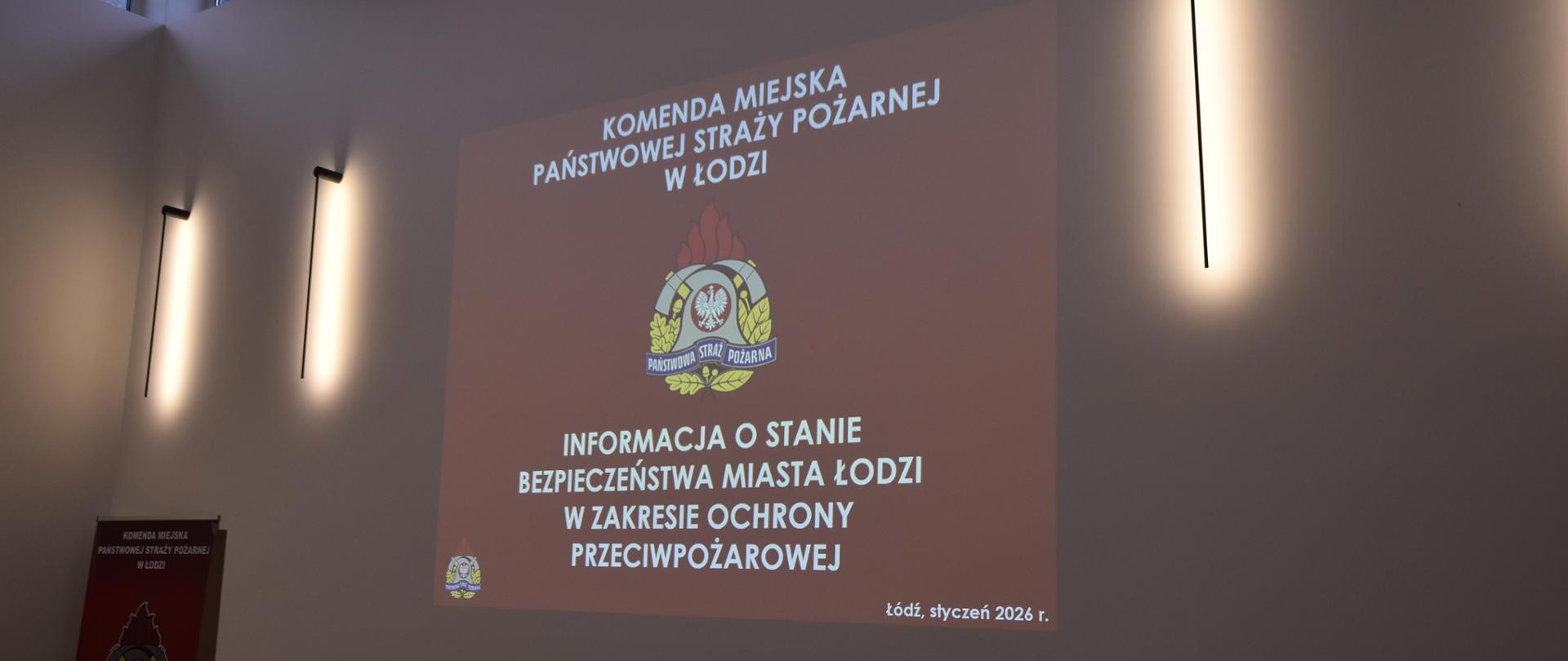 zdjęcie obrazu wyświetlanego z projektora na ścianie logo psp oraz napis informacja o stanie bezpieczenstwa miasta łodzi w zakresie ochrony przeciwpożarowej