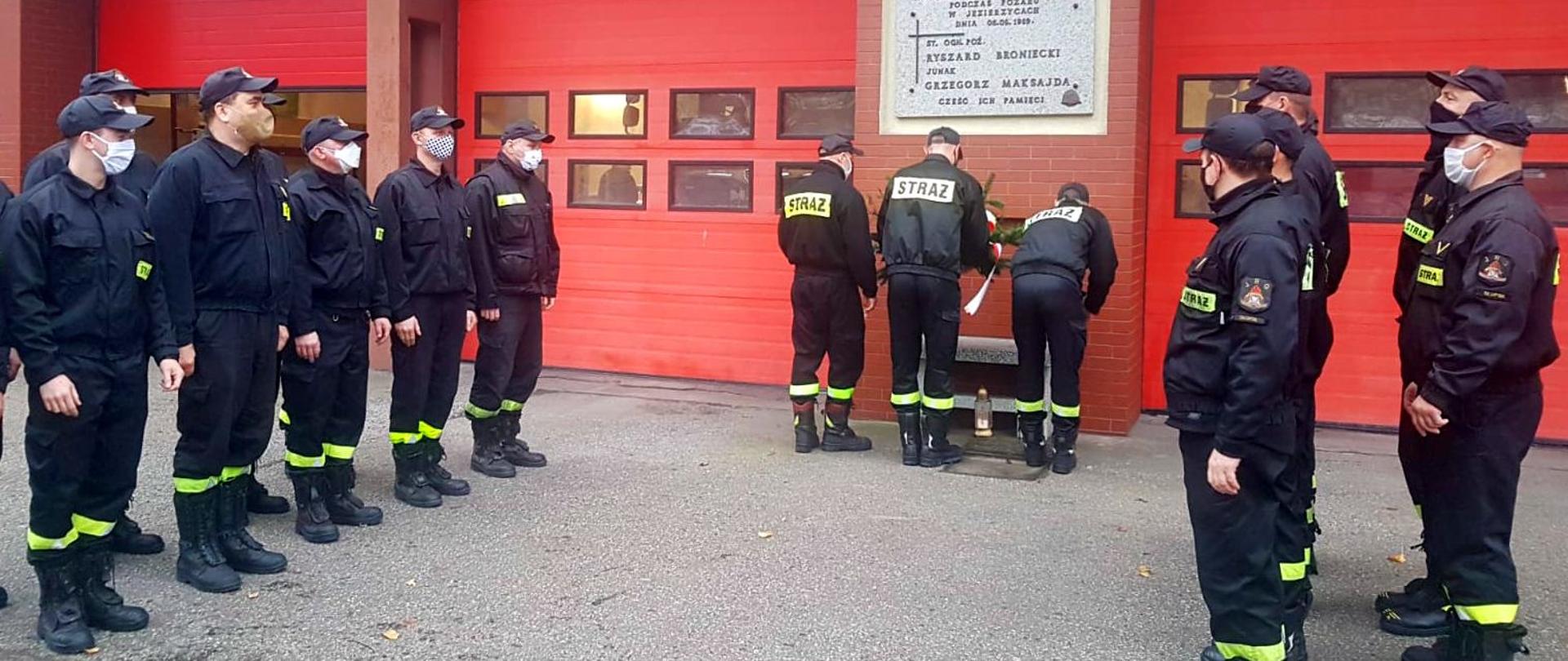 Zdjęcie przedstawia strażaków oddających hołd poległym podczas służby. 