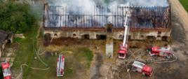 Zdjęcie przedstawia jednostki PSP i OSP działające przy pożarze budynku inwentarsko - gospodarczego w miejscowości Rożniątów.