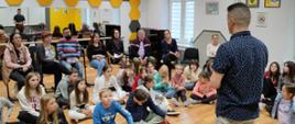 Na zdjęciu znajduje się grupa uczniów, pedagogów i rodziców PSM I stopnia w Jaśle słuchających wykładu Pawła Pietruszki.