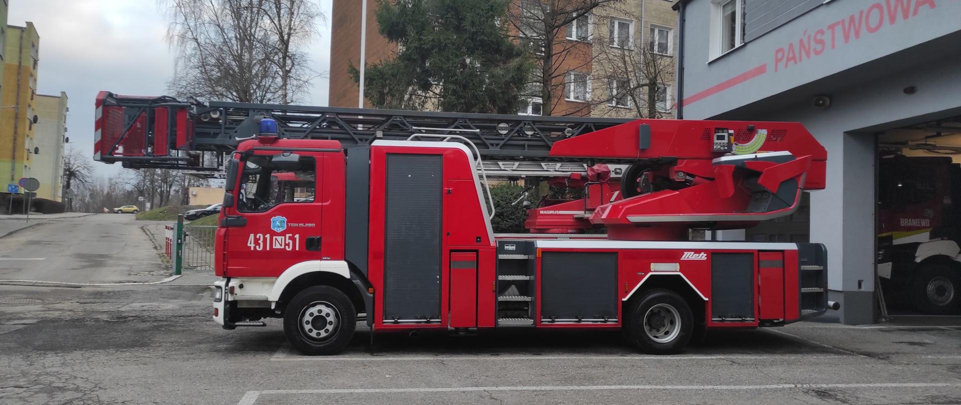 Na zdjęciu samochód specjalny strażacki, duża czerwona drabina mechaniczna.