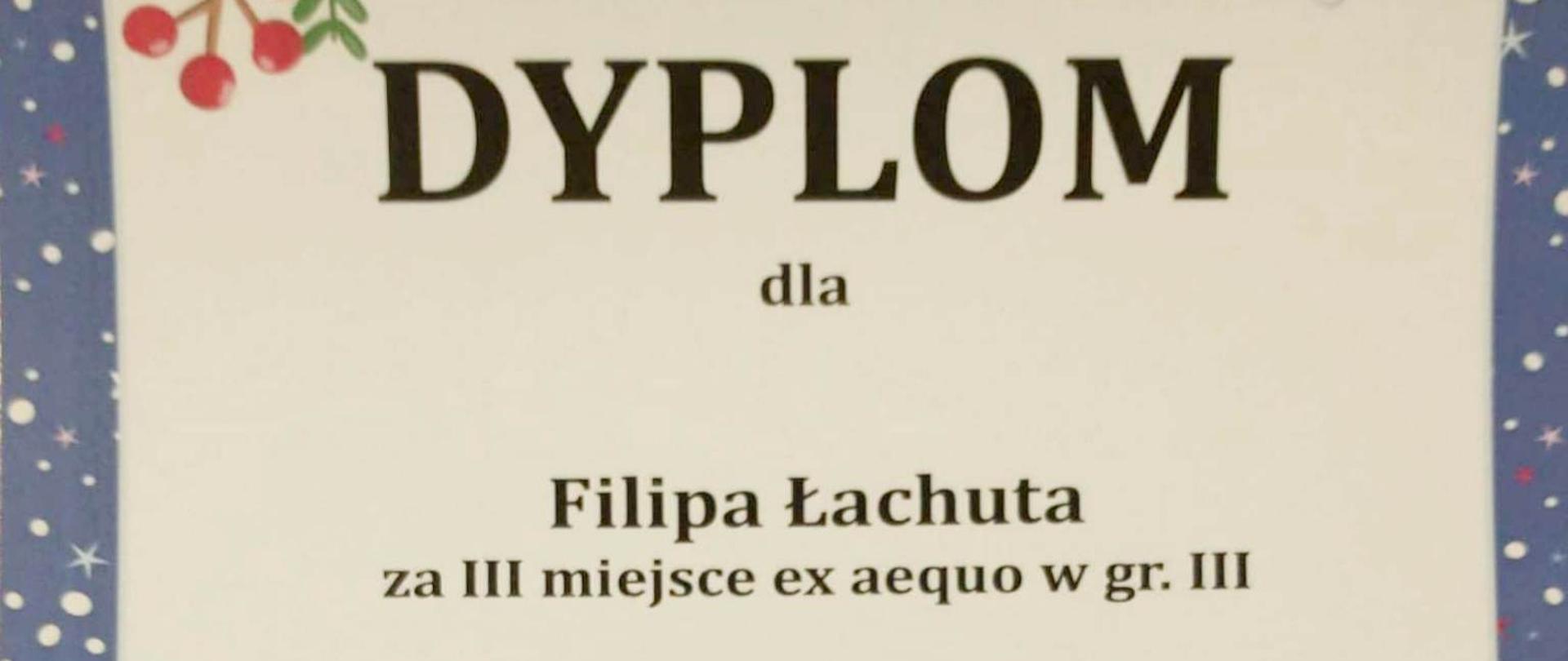 dyplom Filipa Łachuta za III miejsce na XVI Mikołajkowym Konkursie Gitarowym dla Dzieci w Rybniku zawierający czarne napisy na kremowym tle z granatową ramką z motywami świątecznymi i mikołajem w saniach z reniferami w dolnej części dyplomu