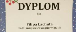 dyplom Filipa Łachuta za III miejsce na XVI Mikołajkowym Konkursie Gitarowym dla Dzieci w Rybniku zawierający czarne napisy na kremowym tle z granatową ramką z motywami świątecznymi i mikołajem w saniach z reniferami w dolnej części dyplomu