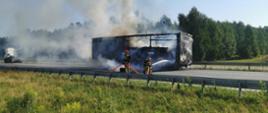 Wąsosz - pożar naczepy - miejsce zdarzenia, strażacy podczas działań gaśniczych, silne zadymienie z płonącej naczepy