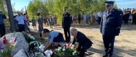 Wojewoda pomorski, harcerka w asyście przedstawicieli Państwowej Straży Pożarnej oraz Policji składają wieniec oraz znicz pod tablicami upamiętniającymi śmierć dwóch harcerek.