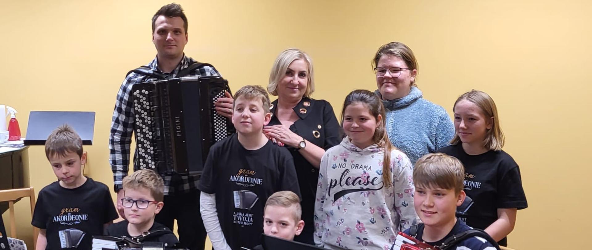 Zdjęcie grupy warsztatowej - grupa uczniów stoi z akordeonami razem z naucz. Ewą Rudzką-Sługocką i dr Marcinem Jabłońskim