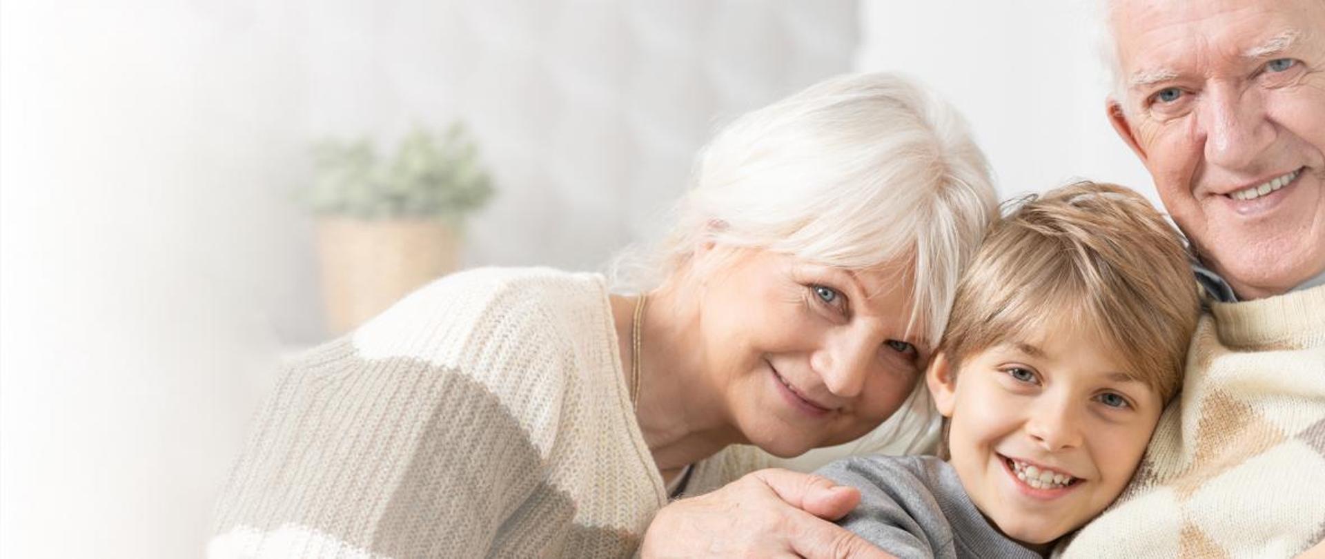 zdjęcie przedstawia dwóch seniorów z wnuczkiem