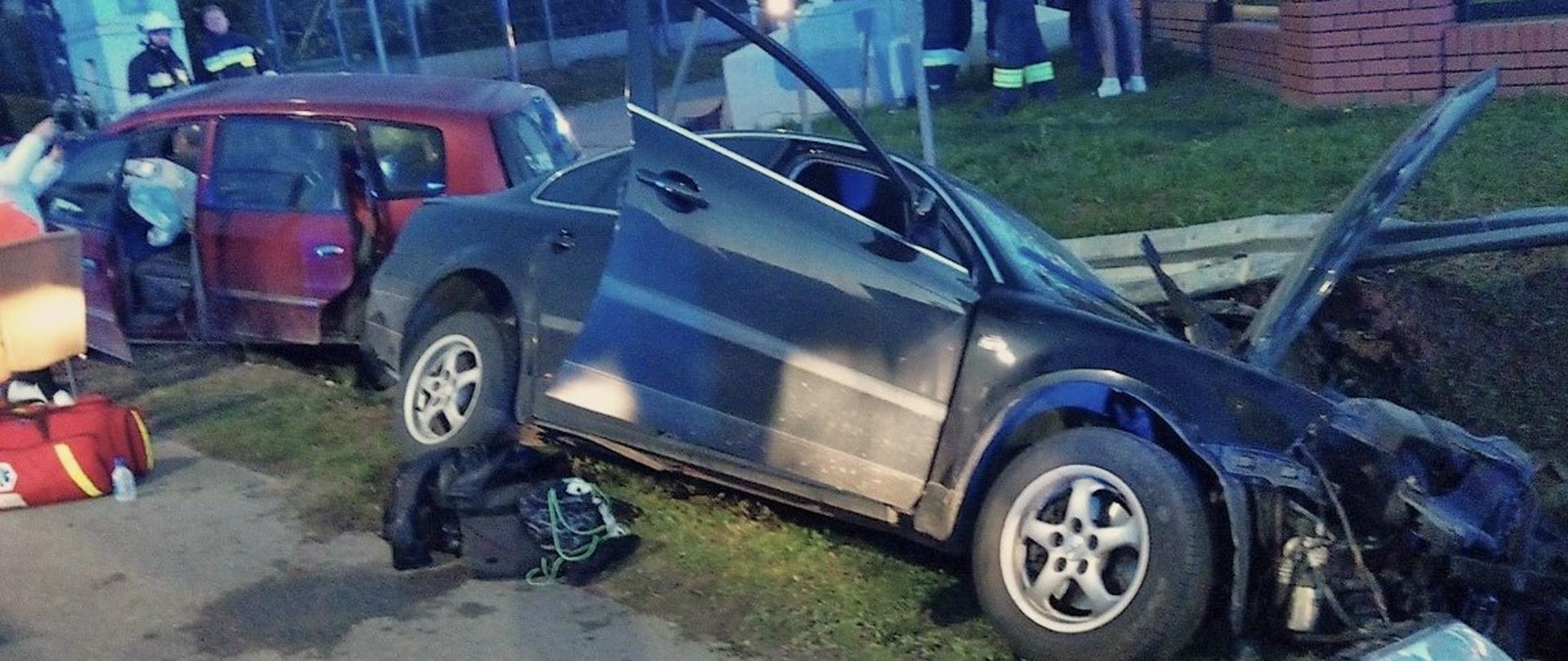 Zdjęcie przedstawia dwa samochody po zderzeniu. Znajdują się przydrożnym rowie.