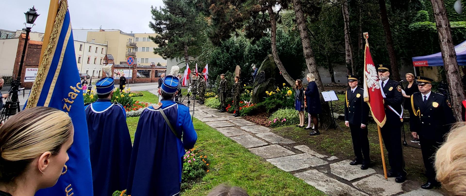 Poczty sztandarowe ze sztandarami pod pomnikiem.