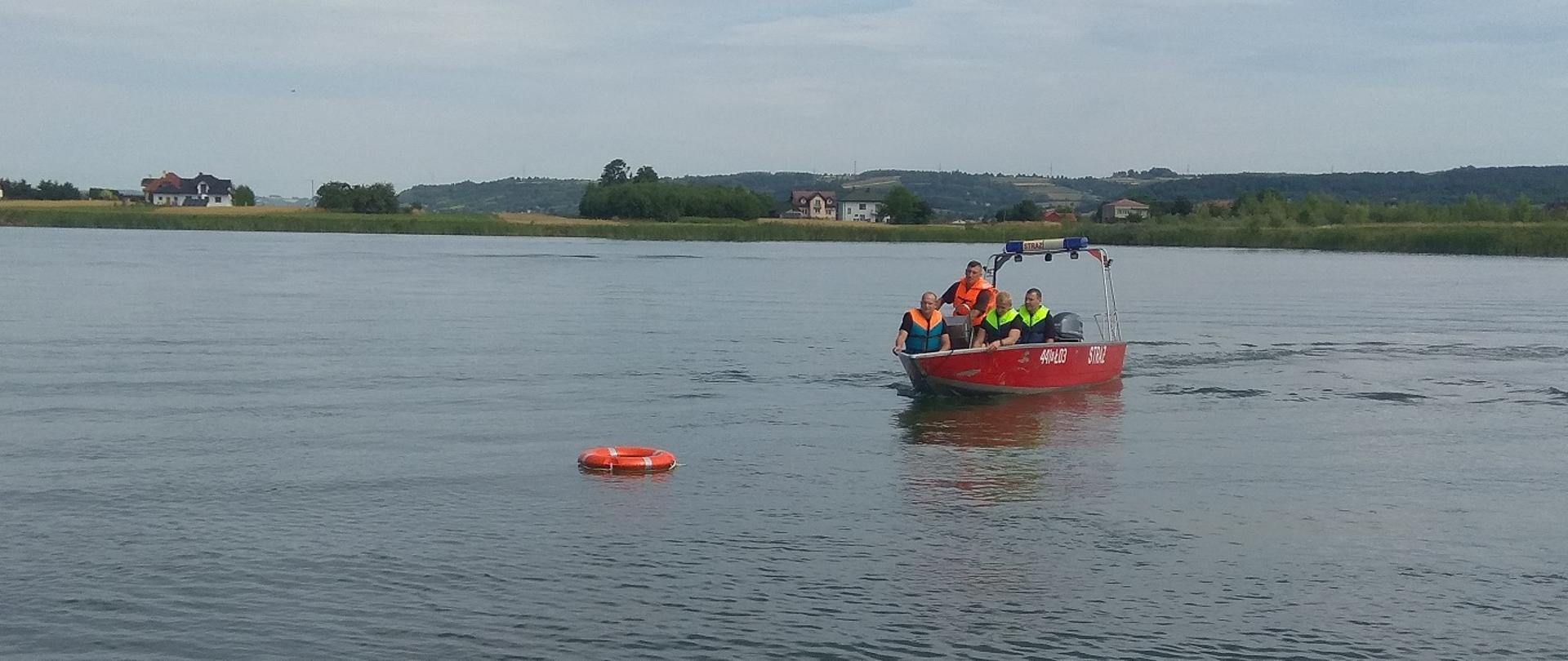 strażacy na łodzi na stawie w Miejscowości Ujazd