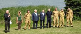 Strażacy, Policja i goście na zdjęciu grupowy na tle jeziora