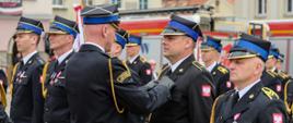 Zastępca Śląskiego Komendanta Wojewódzkiego wręcza odznaczenia stojącym w pododdziale strażakom