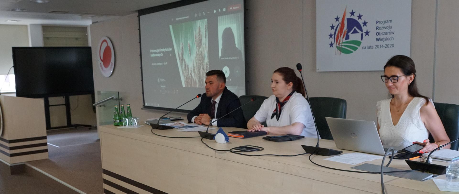 Sekretarz stanu Anna Gembicka podczas spotkania, siedząca za stołem prezydialnym